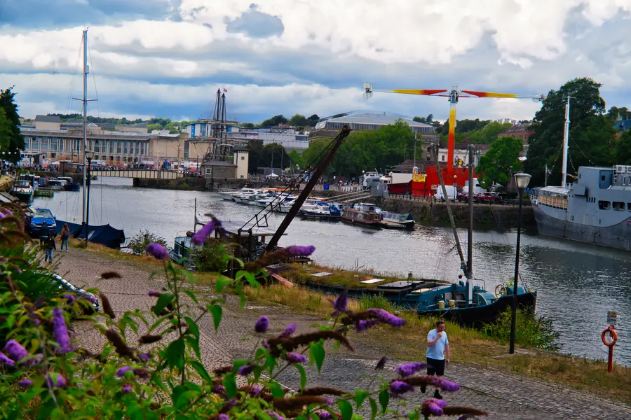 Boats moored along the harbour under a cloudy sky.