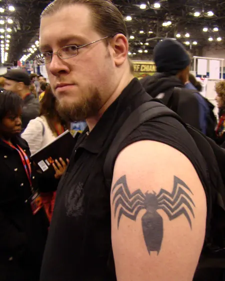 A black spider design on a man's upper arm.