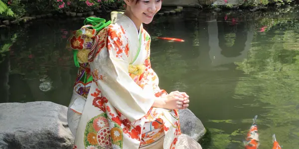 An outdoor koi pond among rocks and planting.